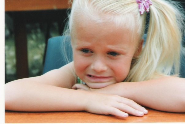 Nici as a child crying at a table